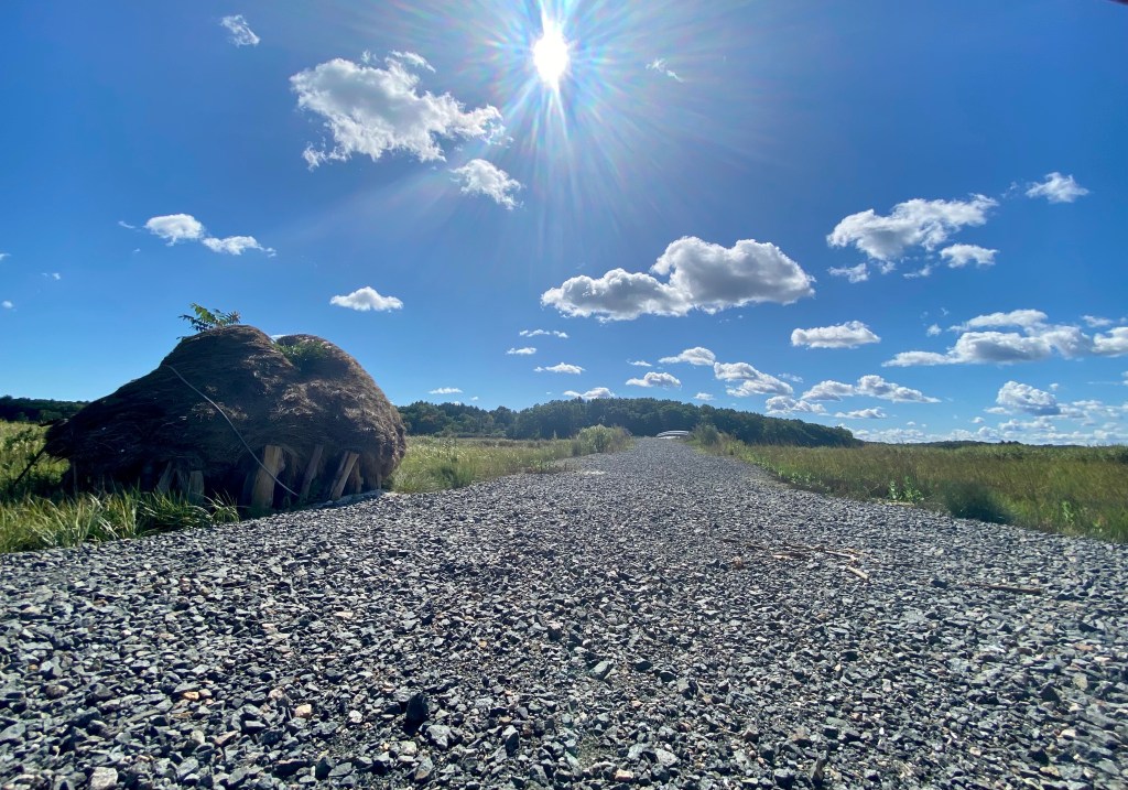 Large hay stack and trail in summer